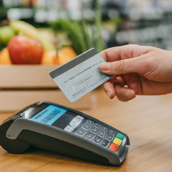 A person holds a prepaid payroll card, preparing for a contactless payment